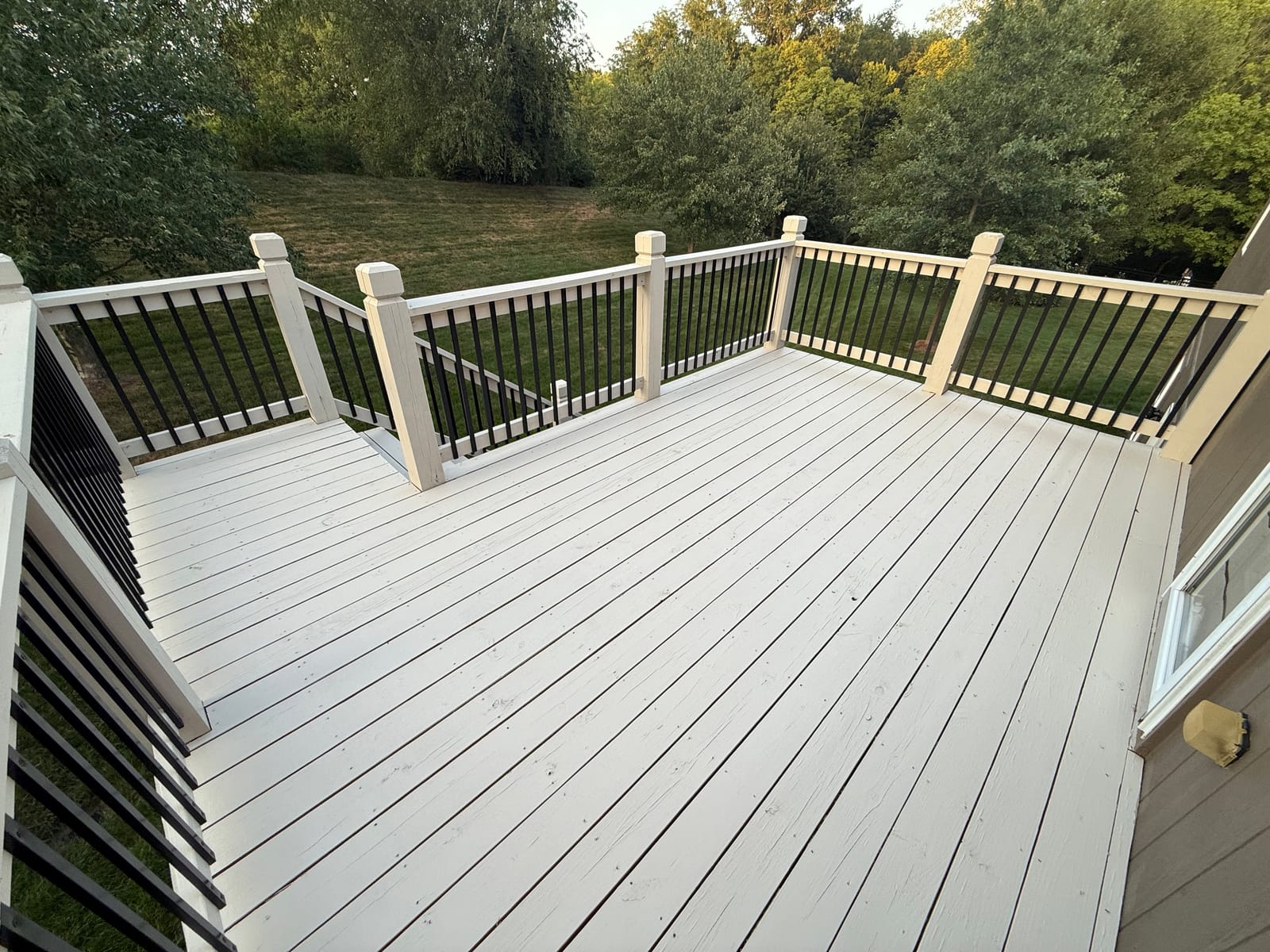 After: Backyard deck stained gray with white railings