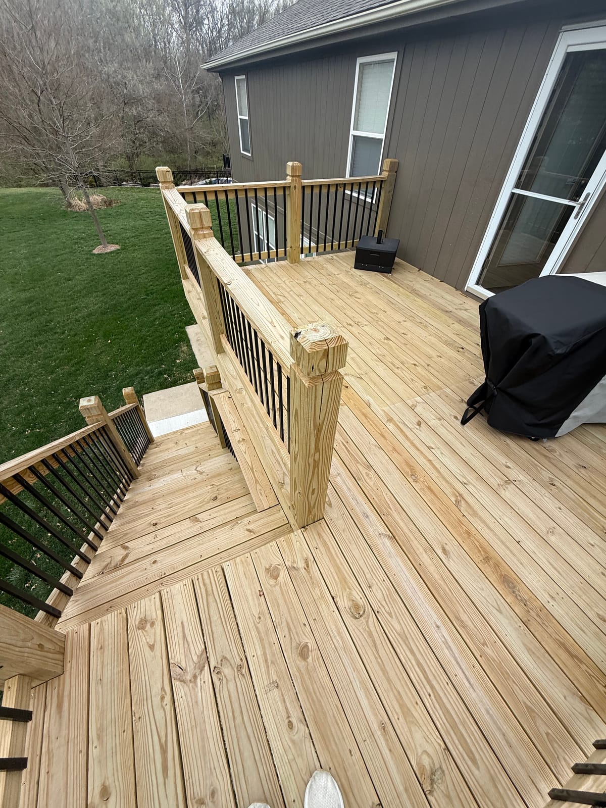 Before: Backyard deck stained gray with white railings