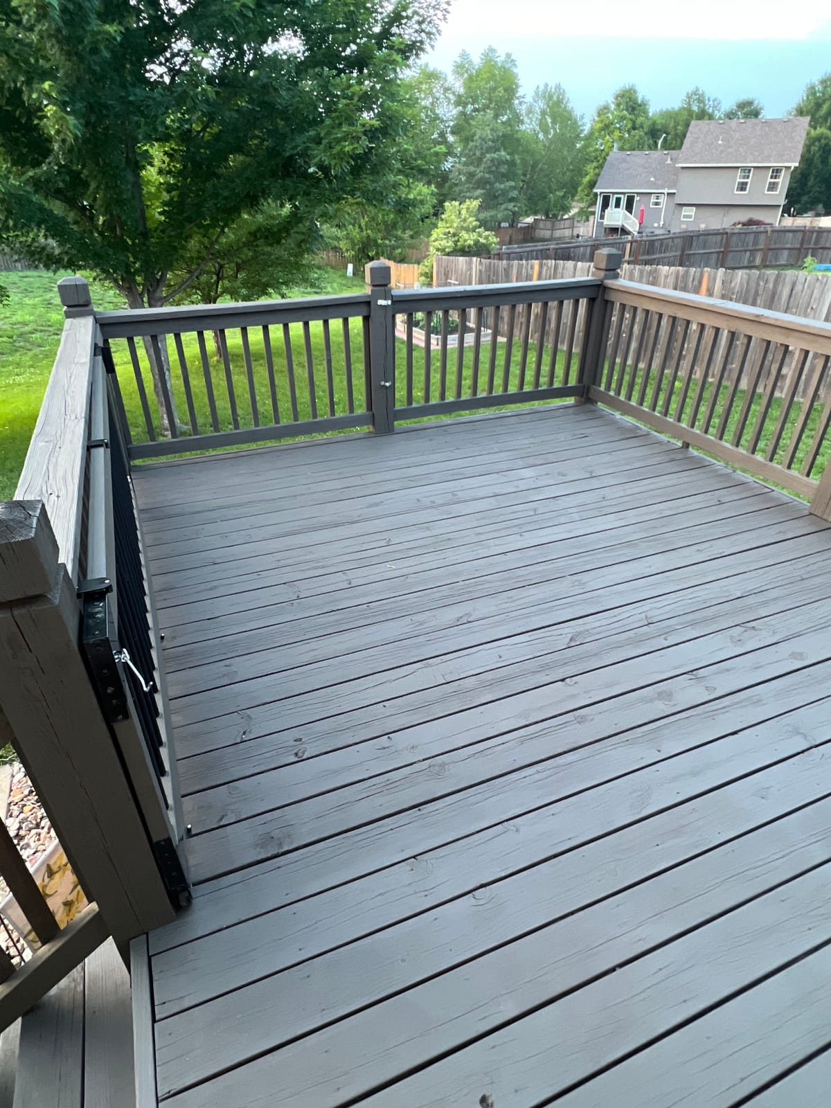 Backyard deck finished in gray with dark brown railings