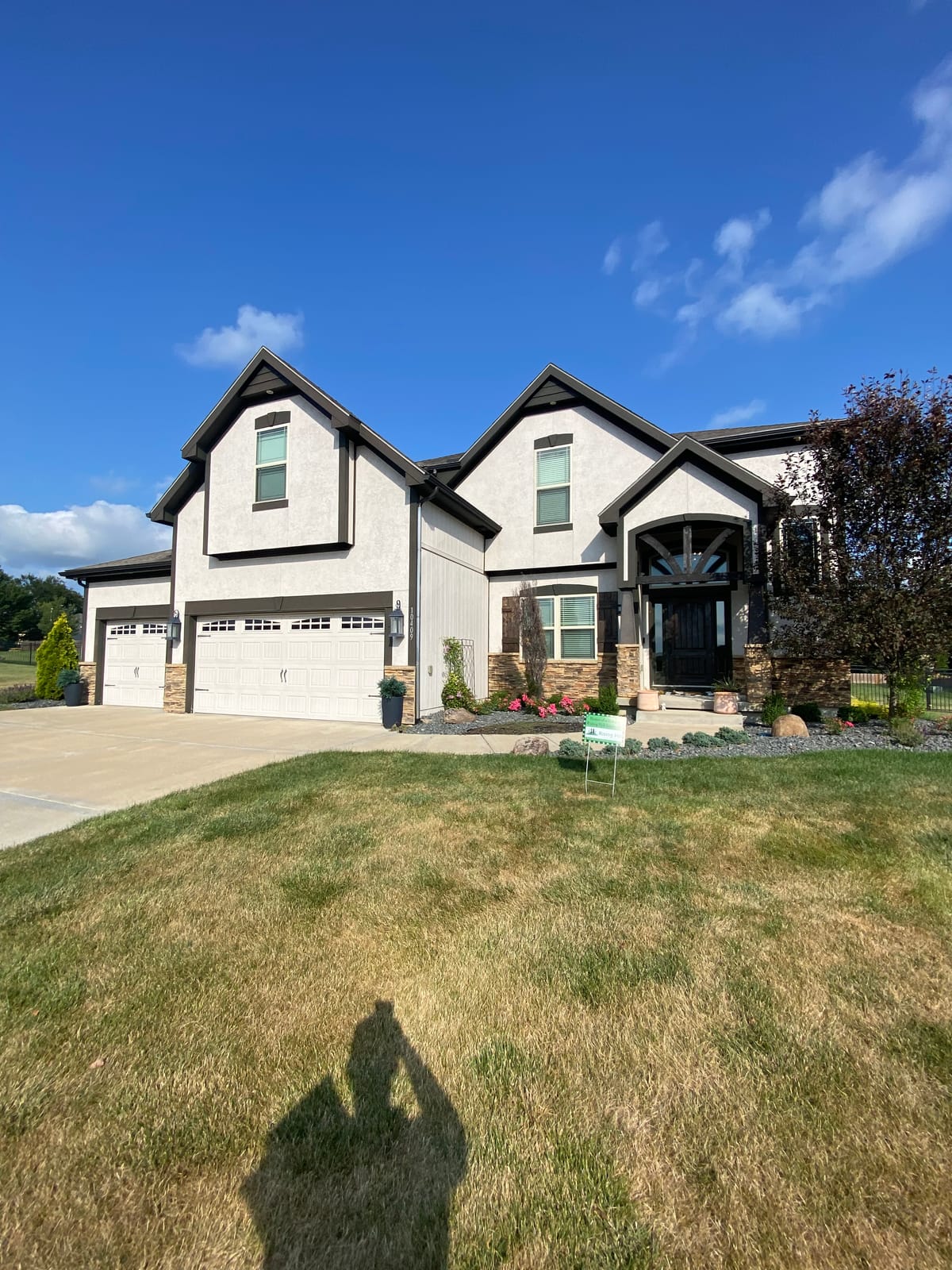 Light gray two-story home with dark trim and multiple gables
