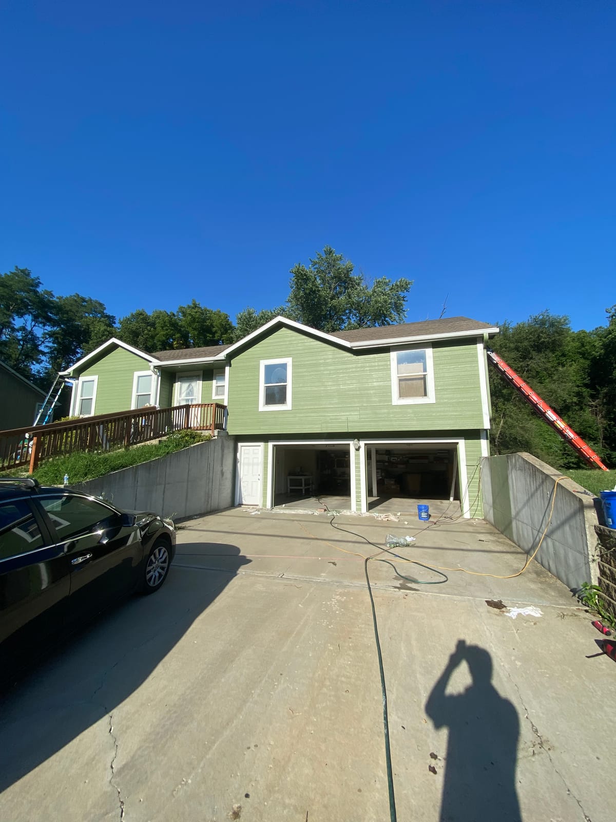 After: Green-sided two-story home before and after an exterior repaint
