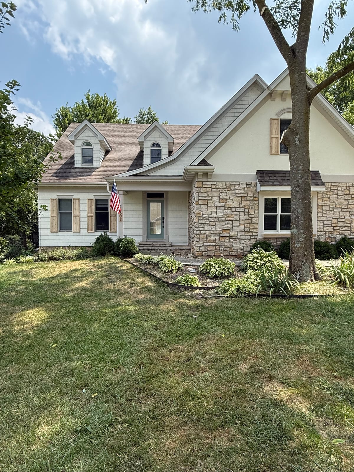 Two-story home with stone and siding and a covered front porch