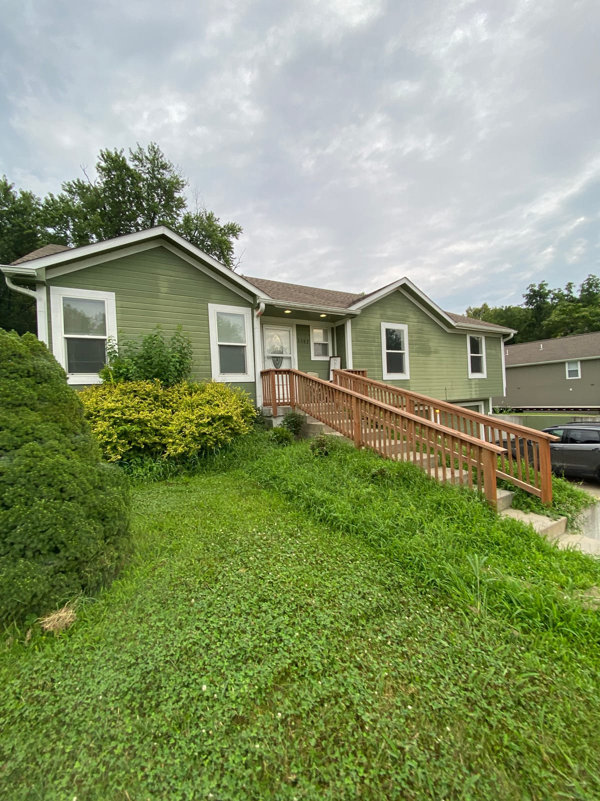 Before: Green-sided two-story home before and after an exterior repaint