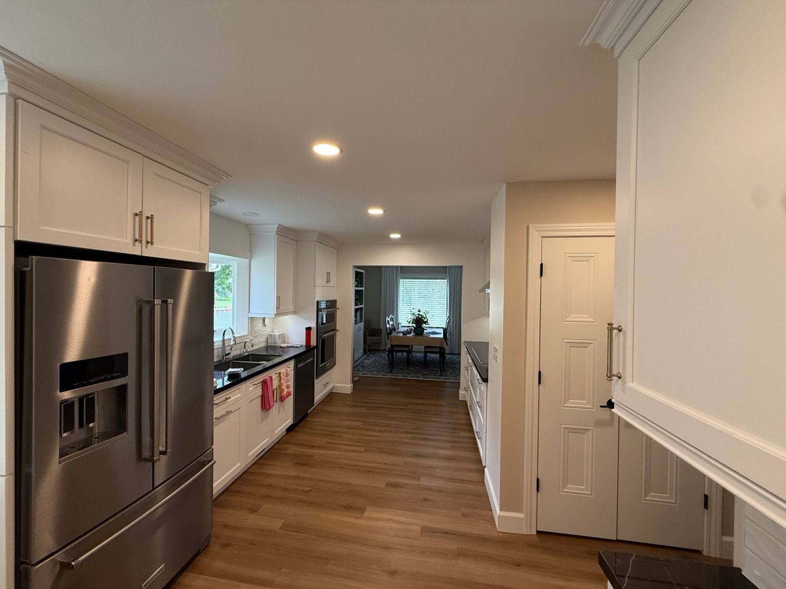Bright kitchen with freshly painted white cabinets and warm wood floors